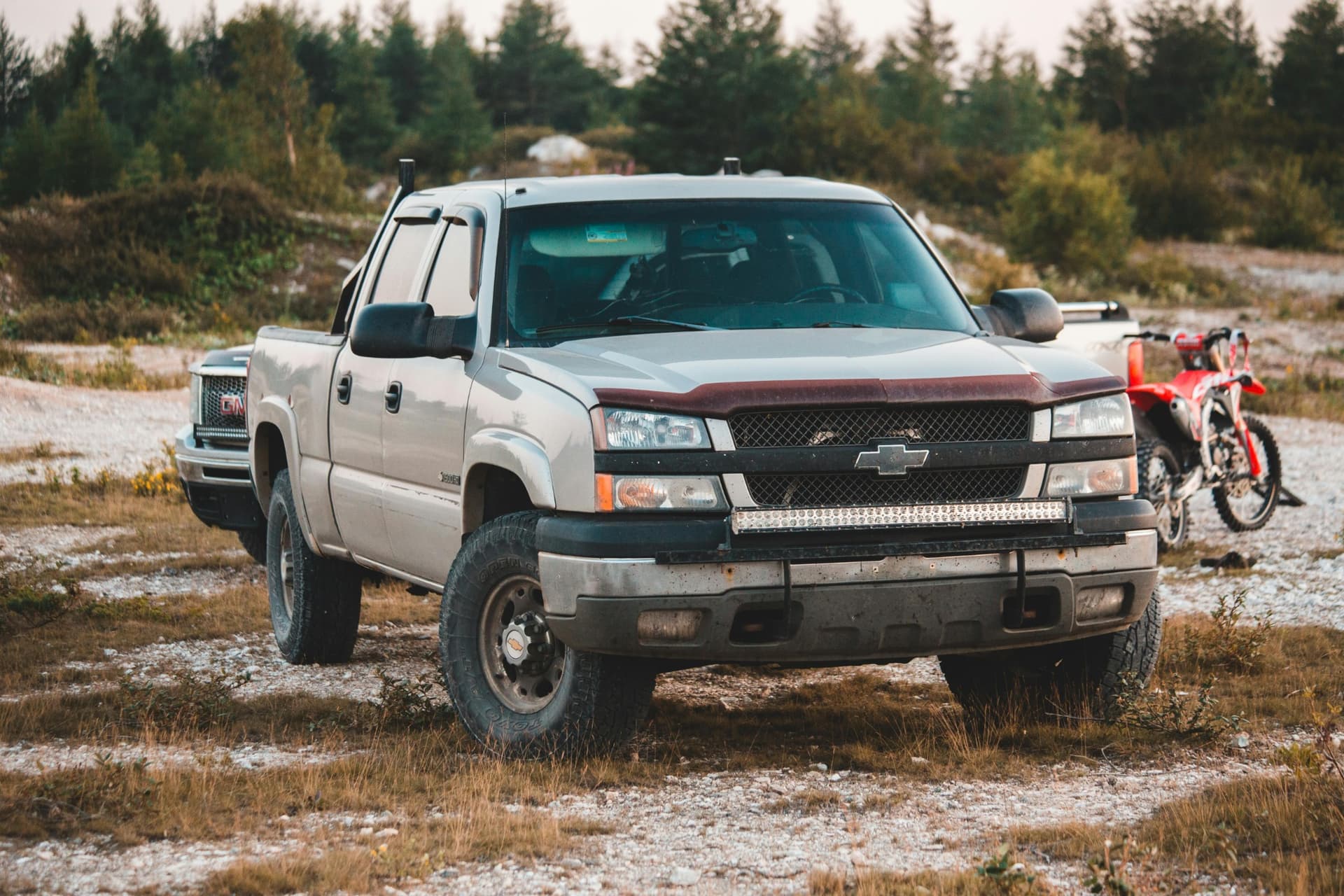 Older model Chevy truck with OZK-installed light bar and upgraded wheels — built for dirt and durability.