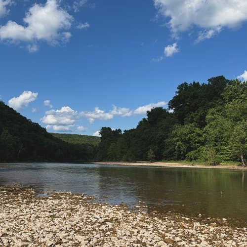 A peaceful riverside camp — the kind of OZK sendoff this platform was designed to support.