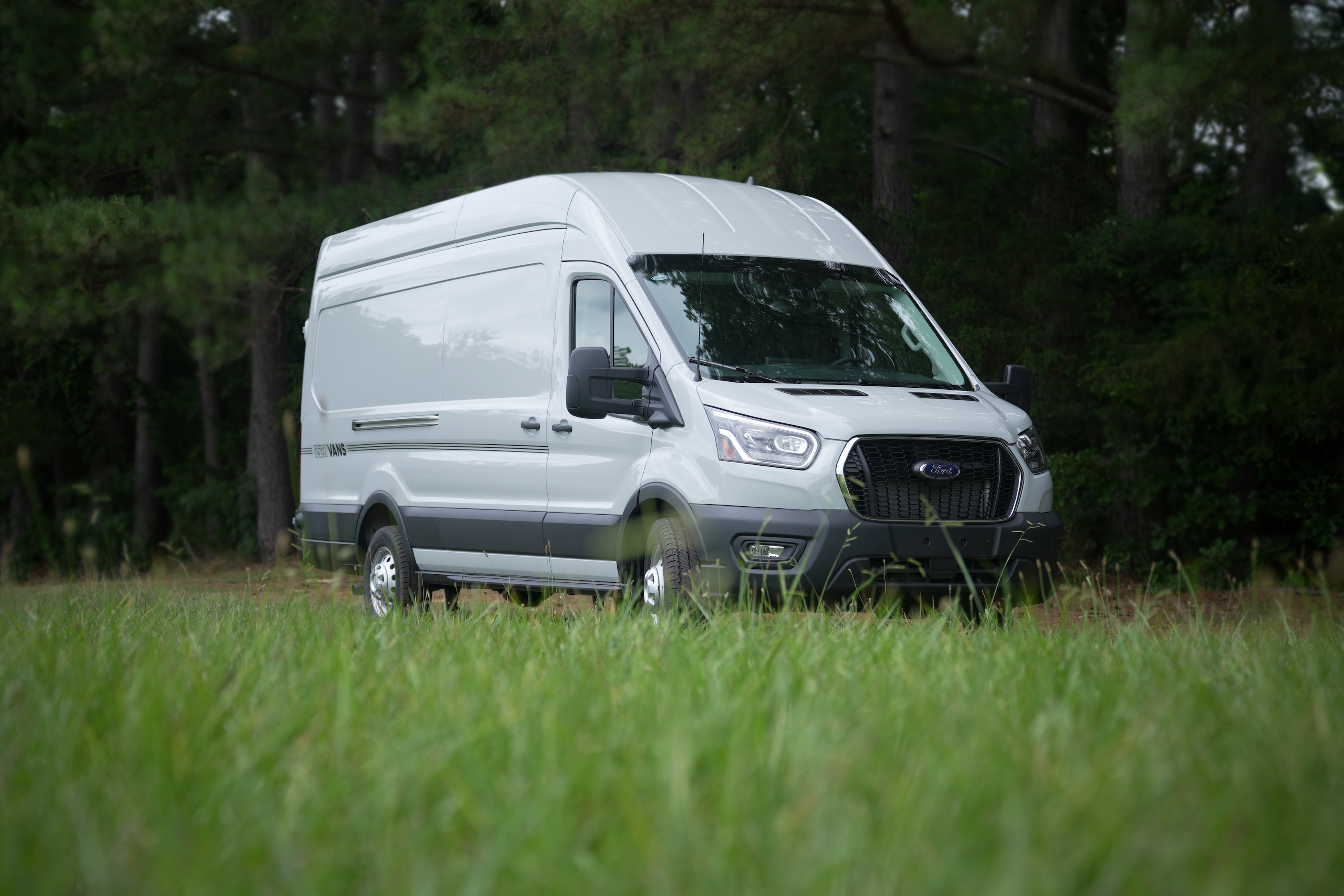 Ford Transit build at OZK Customs featuring full roof rack system, solar, and modular sleeping layout.