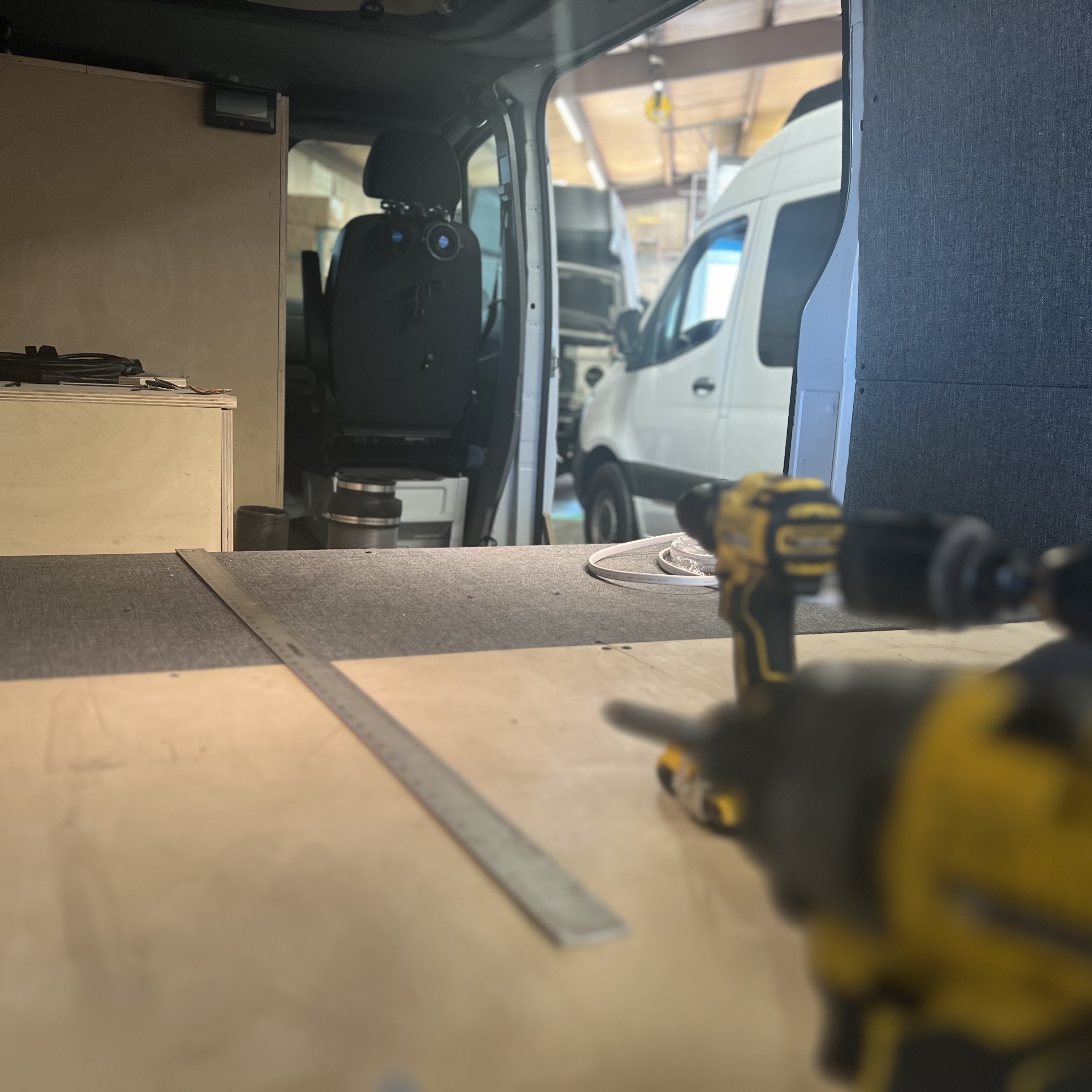 A Ram ProMaster upfit in progress at OZK Customs, ready for cabinetry, wiring, and roof gear installation.