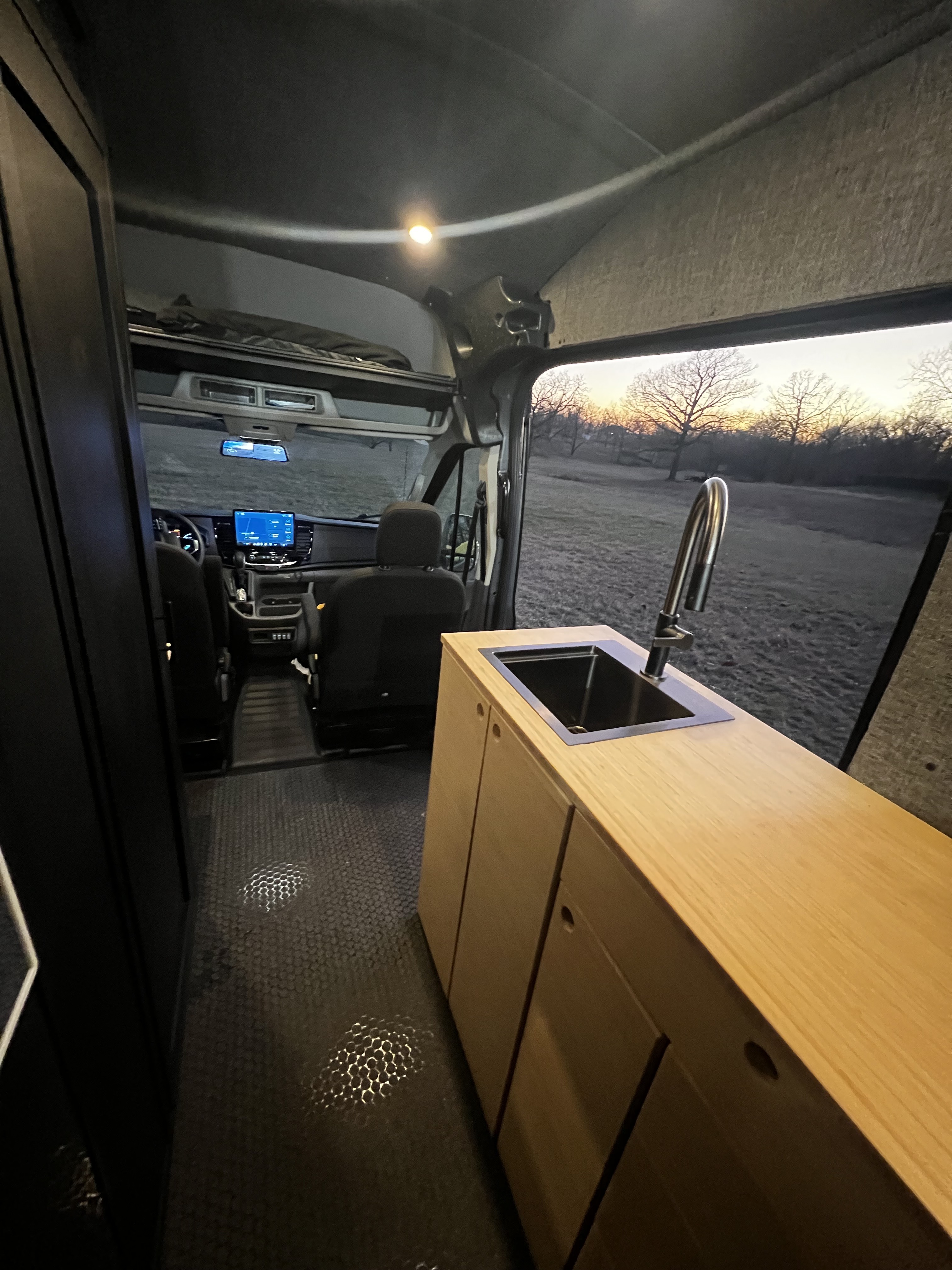 Inside OZK Customs during a van conversion build — each layout is designed around how clients actually use their space.
